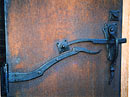 Steel slab door with forged hinges and latch